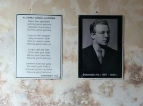 Sinop Cezaevi'nin duvarında yan yana asılı Aldırma Gönül şiirinin metni ve Sabahattin Ali'nin çerçeveli fotoğrafı