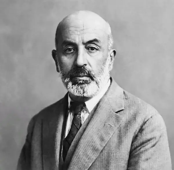 Mehmet Âkif Ersoy'un kır sakallı, açık renk takım elbiseli ve kravatlı hâliyle siyah-beyaz portresi