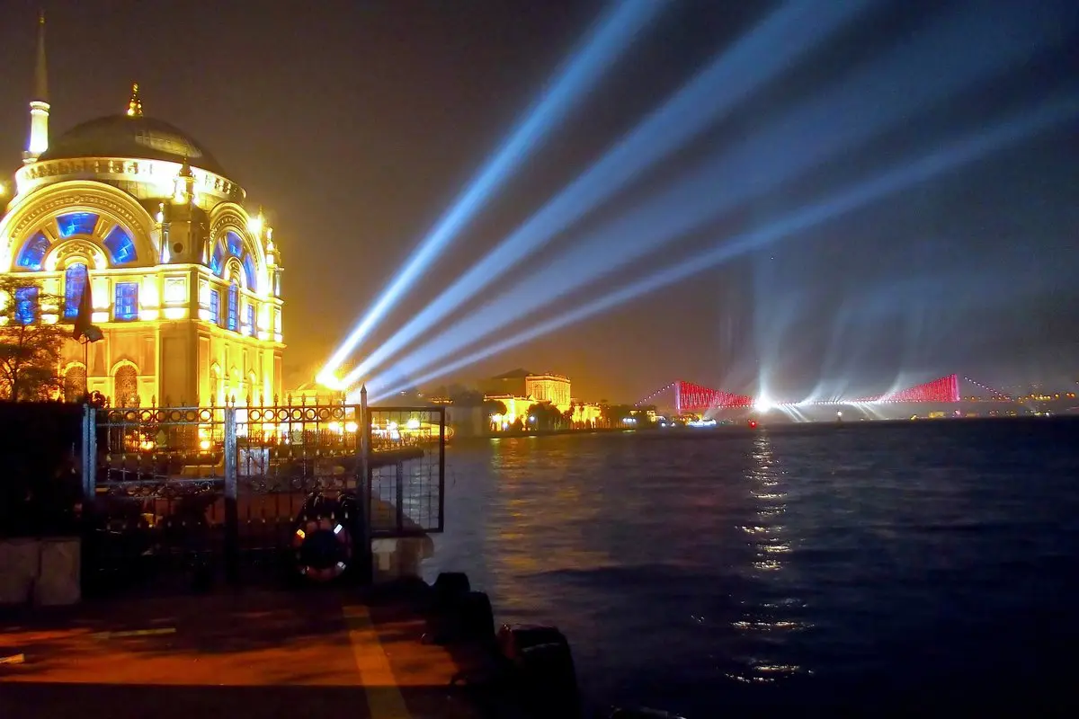 Cumhuriyet'in 90. yılı gecesi Ortaköy Camii'nin ışıklandırılmış cephesi, Boğaz üzerinde gökyüzüne uzanan mavi ışık huzmeleri