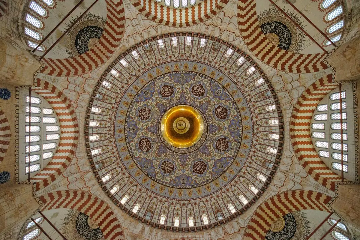 Edirne Selimiye Camii'nin içeriden bakıldığında kırmızı beyaz kemerler ve pencerelerle çevrili, ortasında altın rengi süsleme olan ana kubbesi