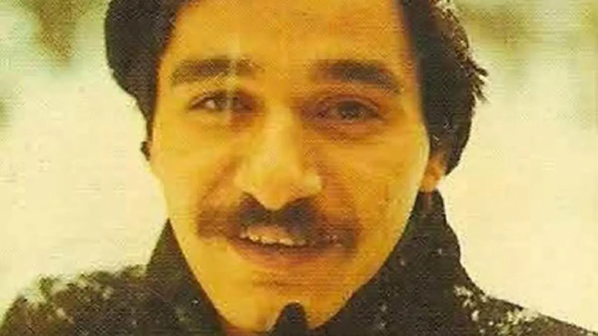 Şair Ahmet Erhan'ın gençlik yıllarından, bıyıklı ve hafifçe gülümseyen yakın plan portresi