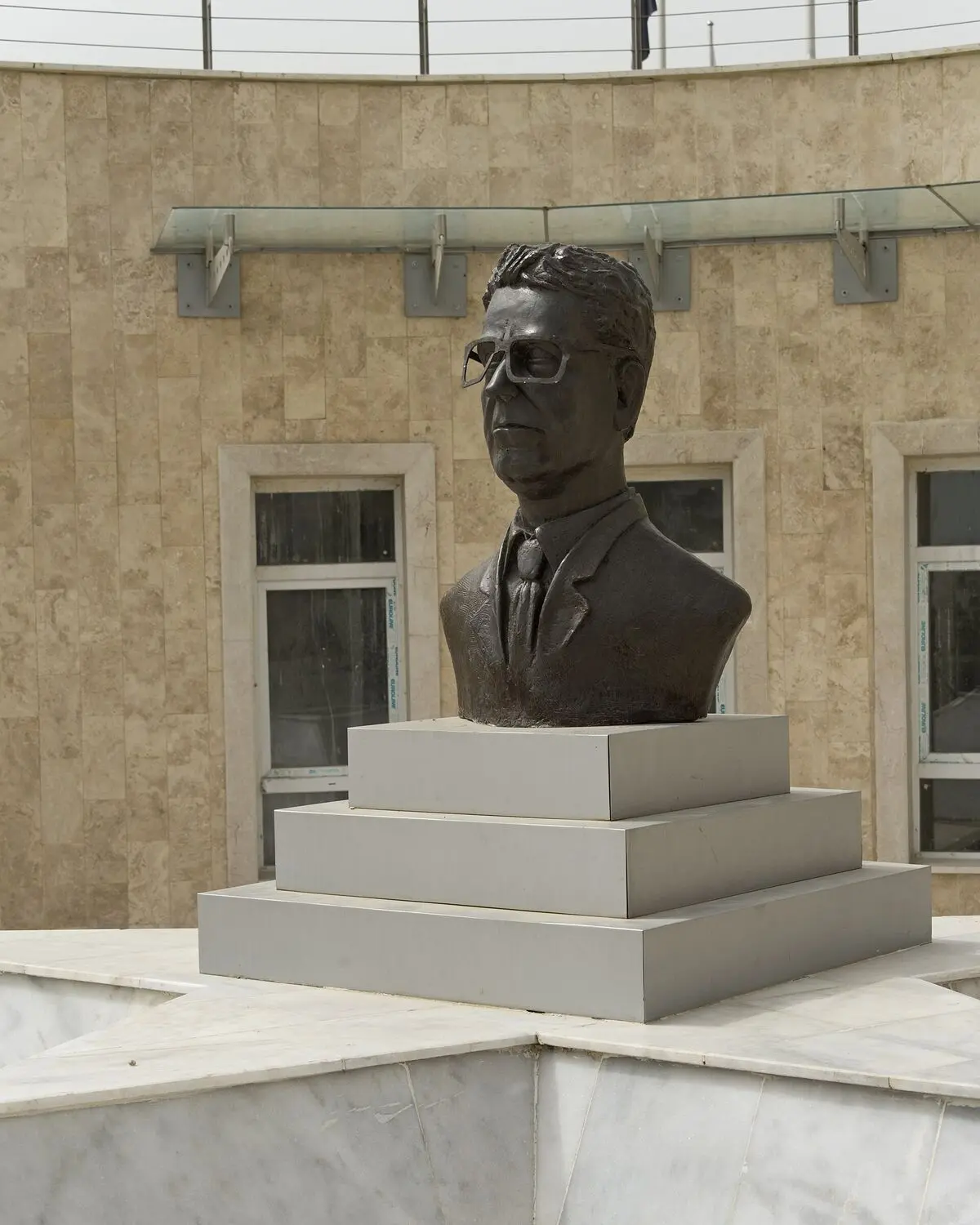 Adana’daki Arif Nihat Asya Bayrak Parkı ve Müzesi’nde, üç basamaklı gri kaide üzerinde gözlüklü şairin bronz büstü