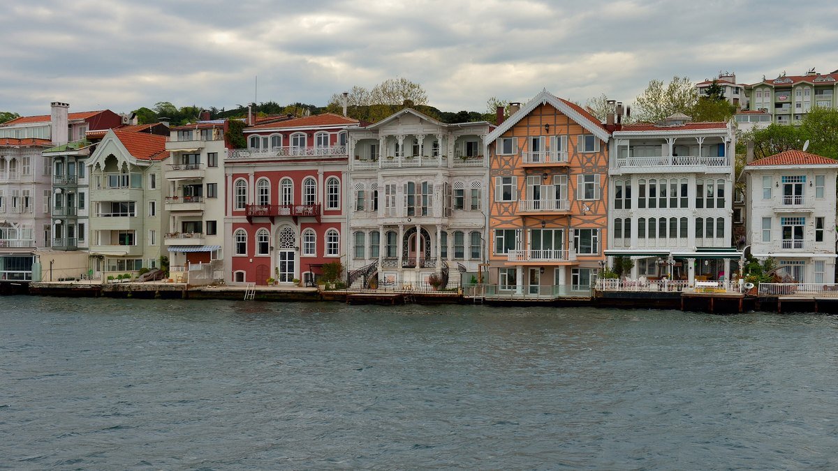 Boğaziçi kıyısında, denizin hemen kenarında yan yana dizilmiş pembe, kırmızı, beyaz ve krem renkli eski ahşap yalılar