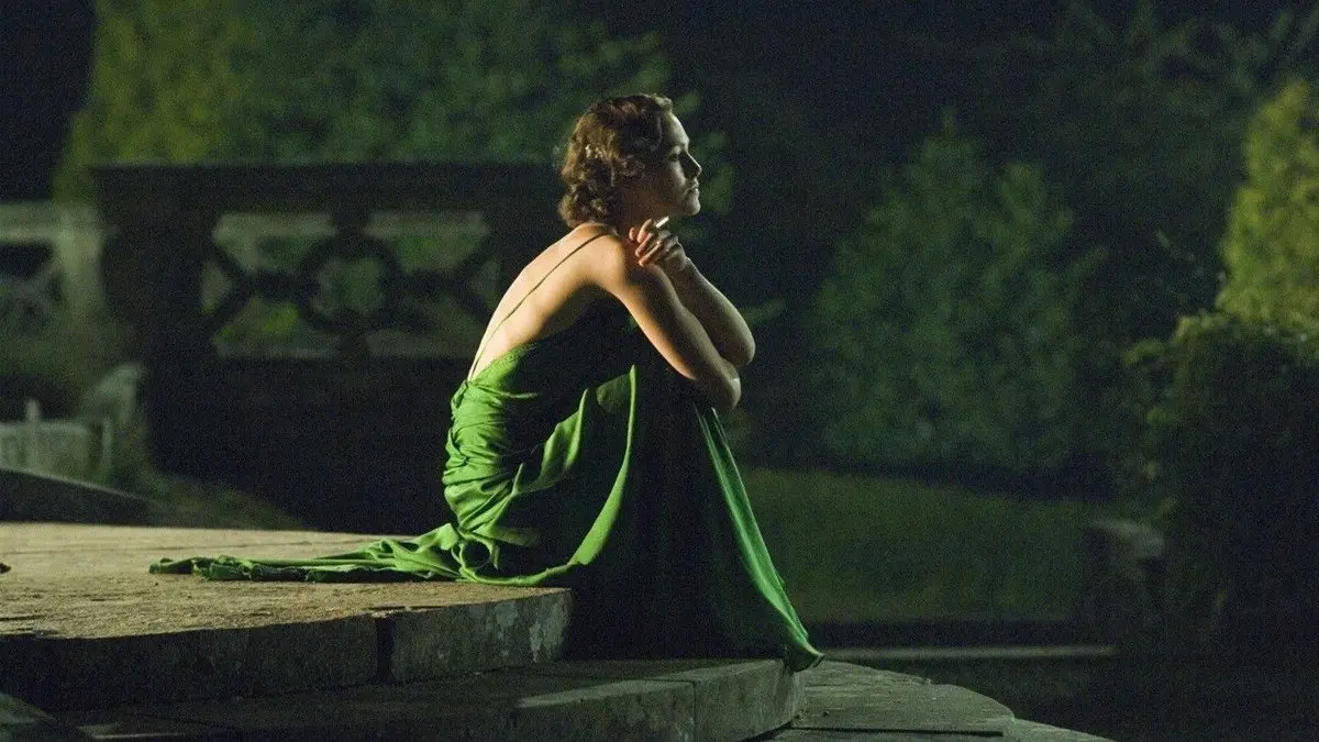 Kefaret (Atonement) filminden sahne: gece vakti bir çeşmenin kenarında oturan yeşil elbiseli Cecilia rolündeki Keira Knightley