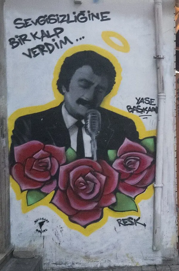 Kadıköy'de beyaz bir duvara çizilmiş, takım elbiseli ve kravatlı Müslüm Gürses'in mikrofon önünde gözleri kapalı şarkı söylediği, altında üç kırmızı gül bulunan duvar resmi