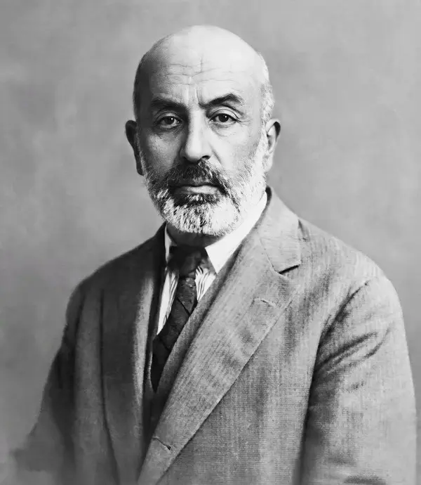 Beyaz sakallı Mehmet Âkif Ersoy’un ceket ve kravatla hafifçe yana baktığı siyah-beyaz portre fotoğrafı
