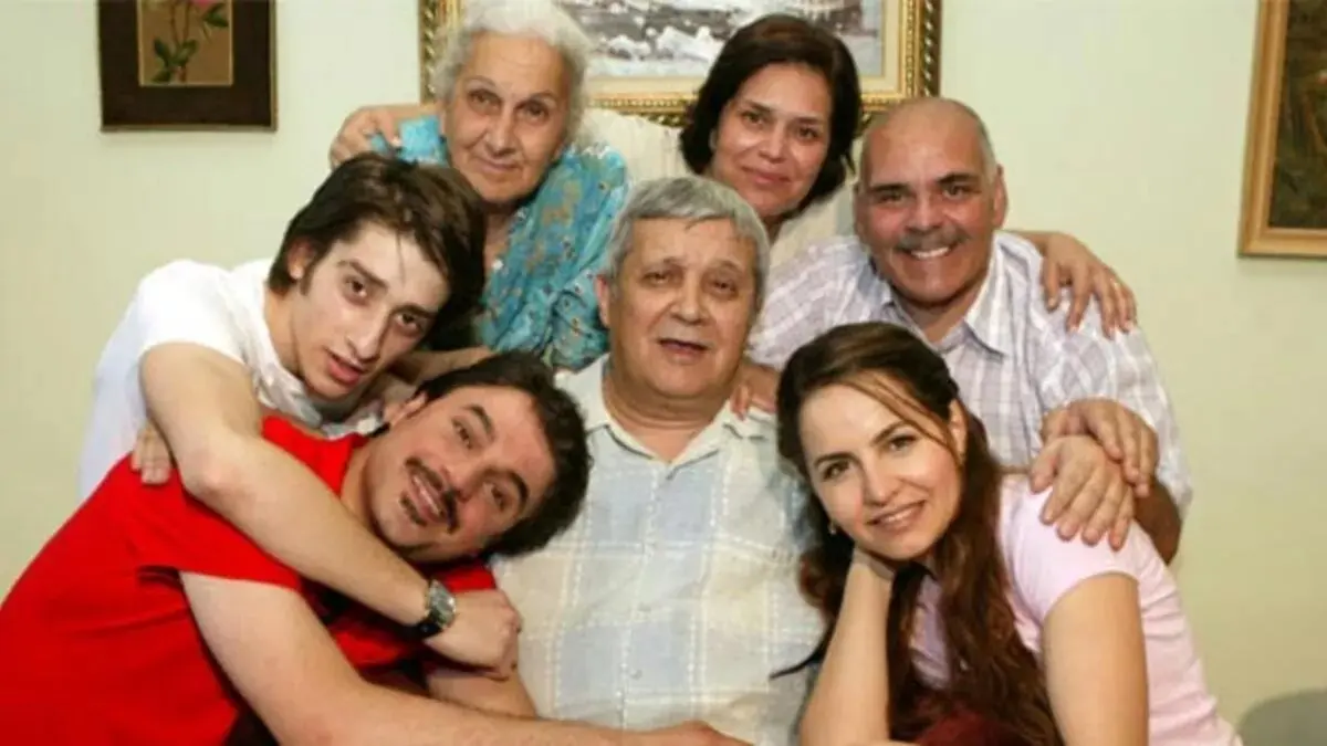 Geniş Aile dizisinin tanıtım görselinde duvarında tablo asılı bir salonda birbirine sarılmış yaşlı kadın, yaşlı adam ve genç aile üyeleri