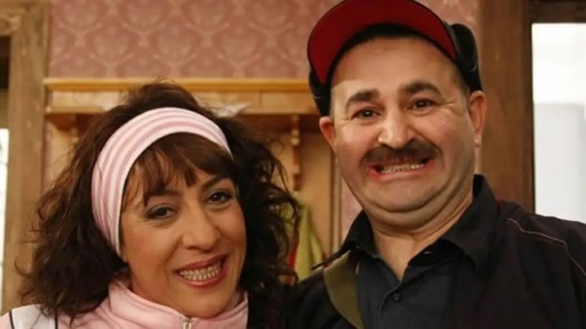 Türk Malı dizisinin tanıtım görselinde pembe saç bantlı, kıvırcık saçlı Abiye ile kırmızı şapkalı, bıyıklı adam yan yana gülümsüyor