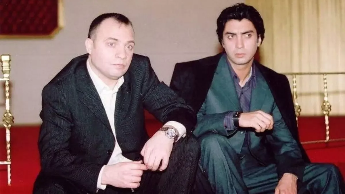 Kurtlar Vadisi dizisinden kırmızı perdeli bir salonda koltukta yan yana oturan, koyu takım elbiseli iki adam