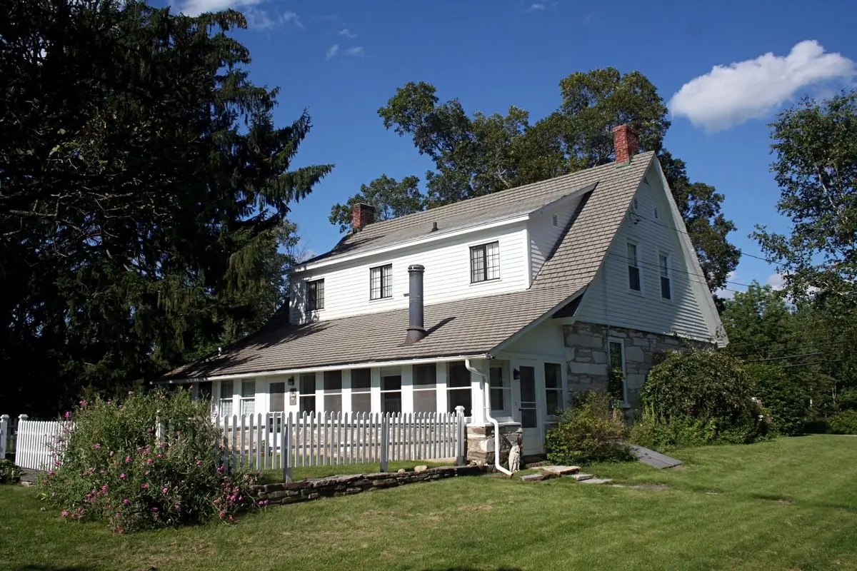 Robert Frost’un Vermont’un Shaftsbury kasabasındaki evi: büyük ağaçların gölgesinde, geniş çimenlik içinde beyaz cepheli iki katlı ev