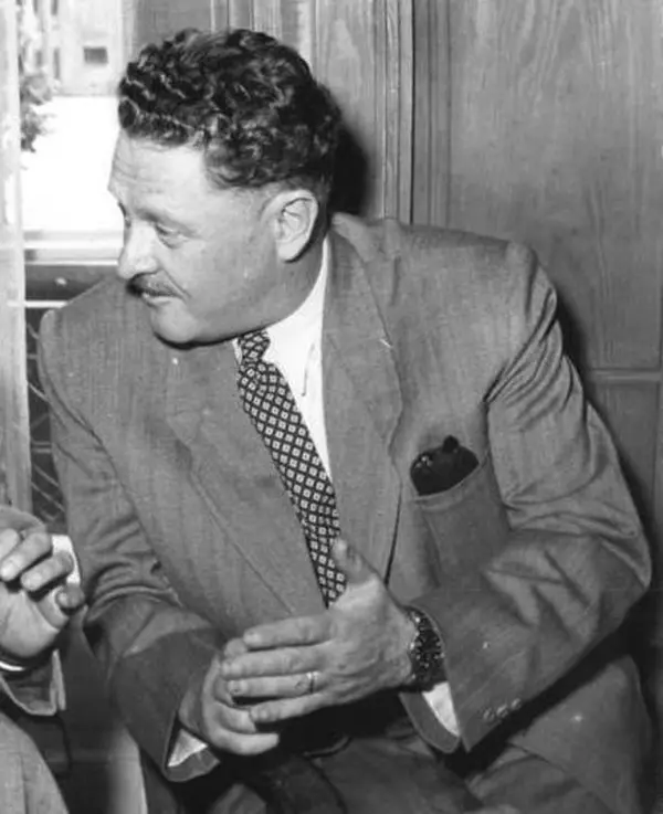 Nâzım Hikmet 1952’de Berlin’de, takım elbise ve kareli kravatla konuşurken çekilmiş siyah beyaz fotoğraf