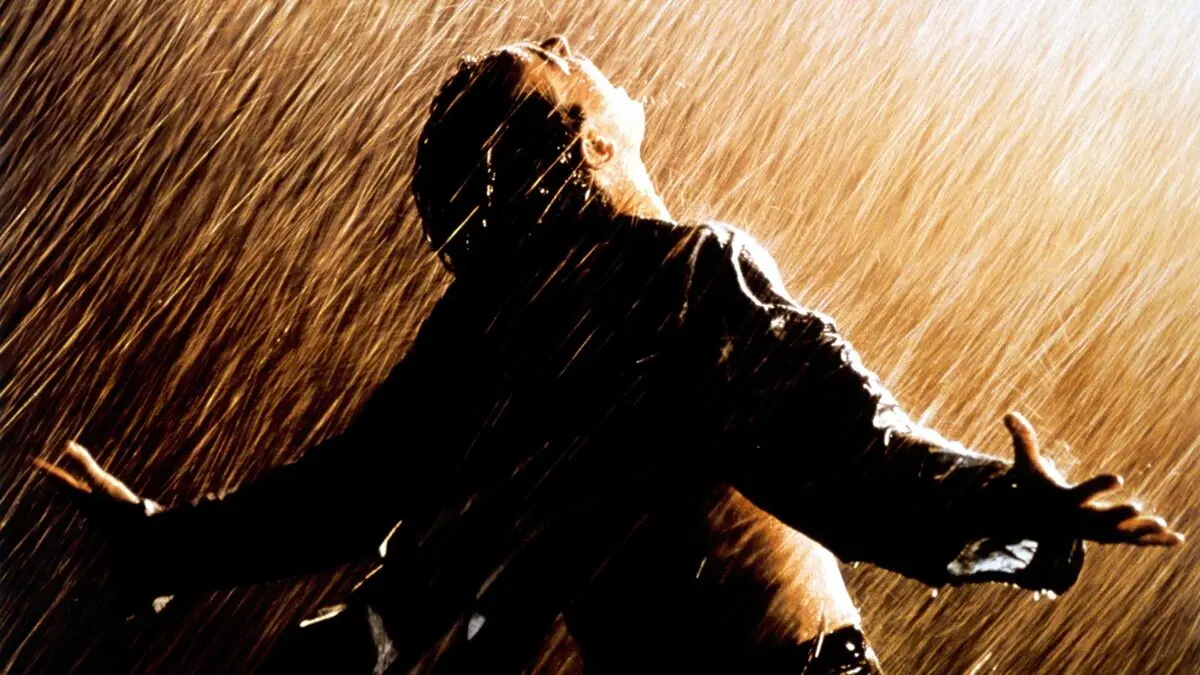 Esaretin Bedeli filminde gece sağanak yağmur altında kollarını iki yana açmış, yüzünü gökyüzüne kaldırmış Andy Dufresne (Tim Robbins); turuncu ışıkta parlayan yağmur damlaları