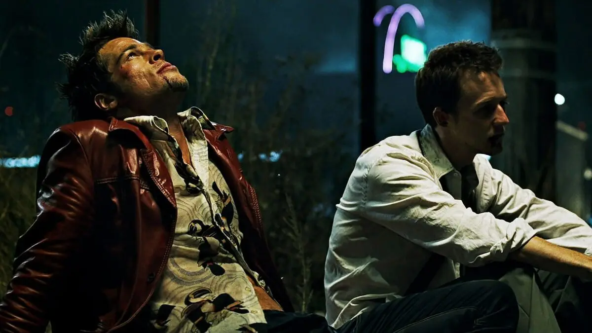 Gece bir barın önünde yere oturmuş, kırmızı deri ceketli Tyler Durden (Brad Pitt) başını geriye atmış; yanında beyaz gömlekli anlatıcı (Edward Norton) ona bakıyor
