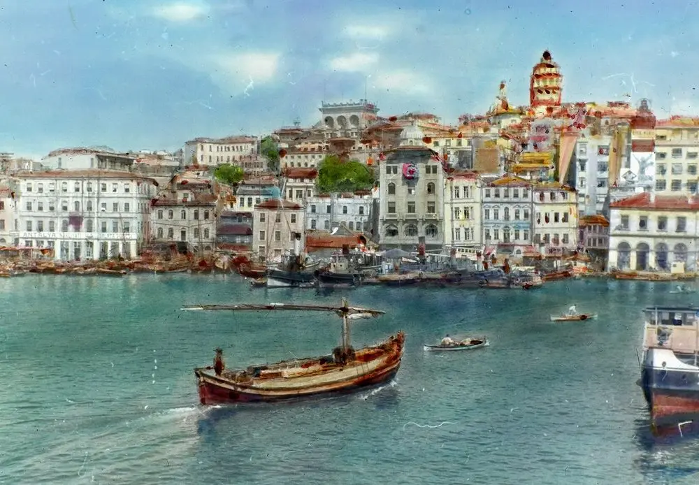 1935 yılında Galata Köprüsü’nden görülen Karaköy kıyısı ve Galata Kulesi, önde kürekli bir kayık ve vapur; renklendirilmiş cam slayt fotoğrafı