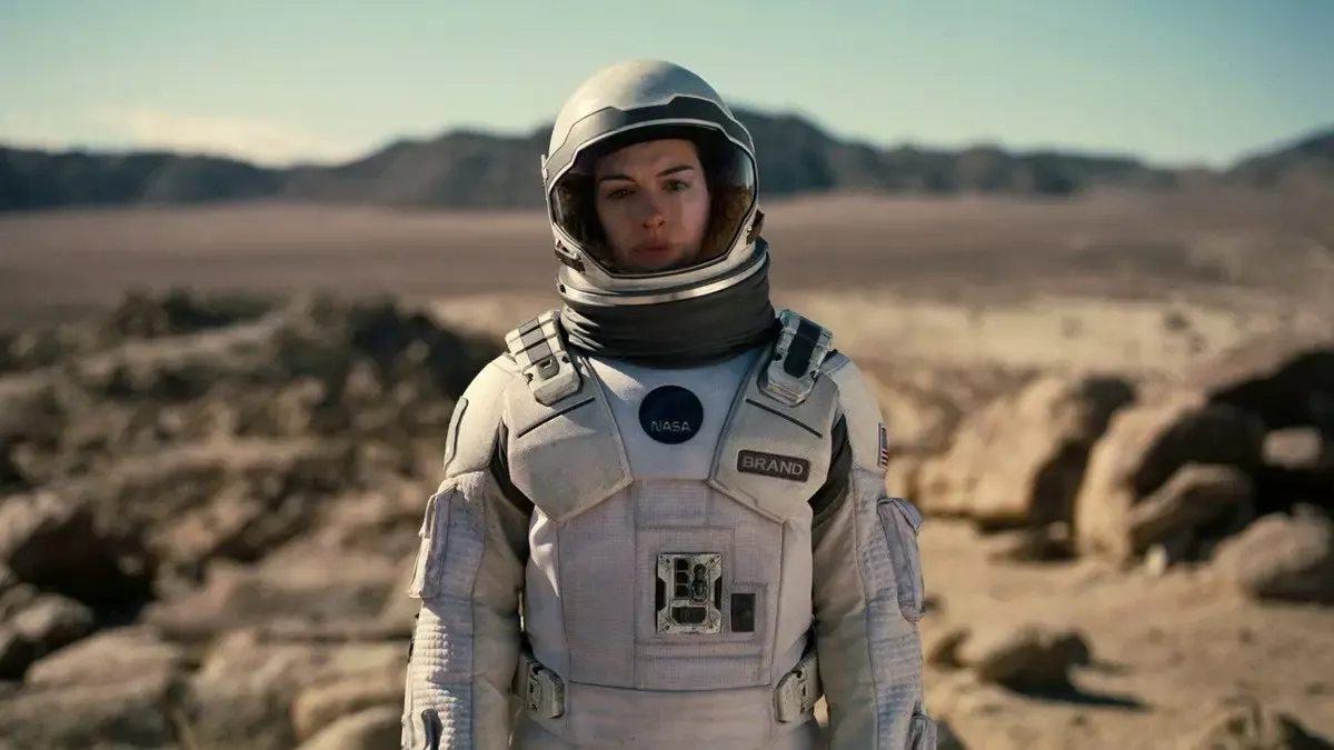 Interstellar filminden sahne: Edmunds’ın kayalık ve çorak gezegeninde kaskını açık tutan uzay giysili Amelia Brand