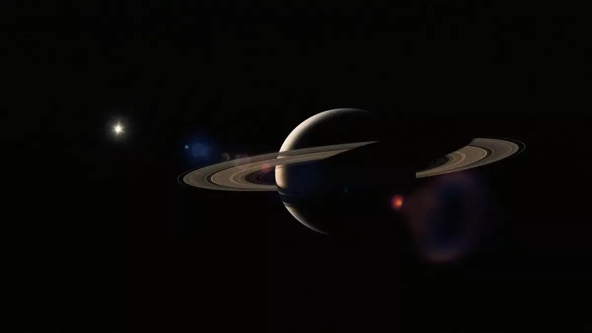 Interstellar filminden sahne: uzay boşluğunda halkalarıyla Satürn ve yanında solucan deliğinin parlayan küresel izi