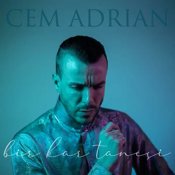 Cem Adrian’ın Bir Kar Tanesi tekli kapağı; mavi ışıkta başını eğmiş Cem Adrian ve el yazısıyla şarkının adı