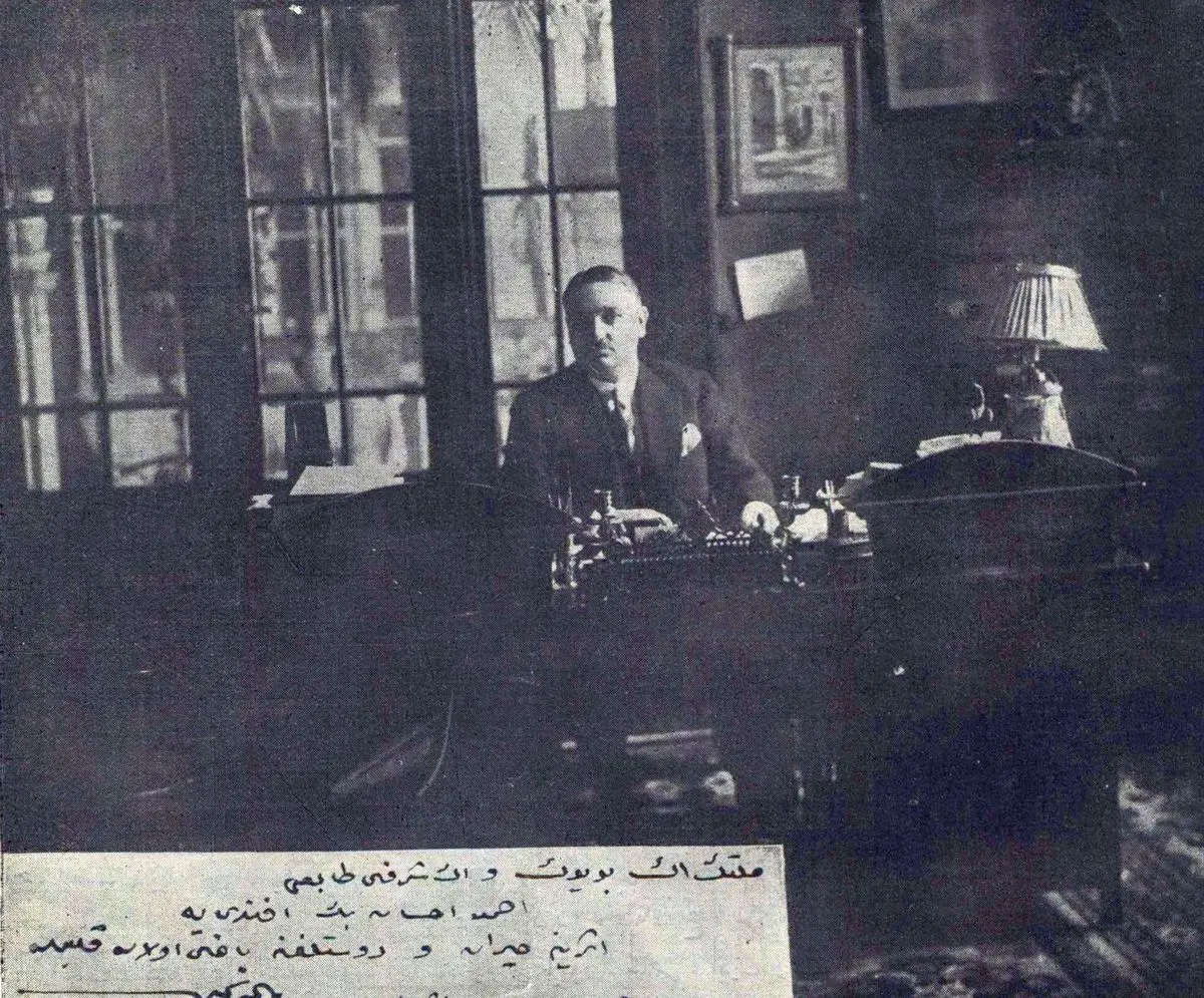 Servet-i Fünun dergisinin 1928 tarihli sayfasında, pencereli bir çalışma odasında masa başında oturan Yahya Kemal; altta Osmanlıca açıklama yazısı