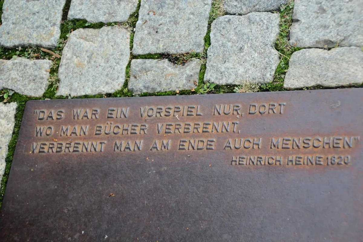 Berlin’deki Bebelplatz meydanında, 1933 kitap yakma anıtının yanında parke taşları arasına yerleştirilmiş metal levha; üzerinde Heinrich Heine’nin kitap yakanların sonunda insan da yakacağını söyleyen Almanca dizeleri yazıyor