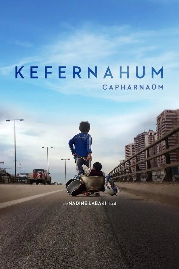 Kefernahum filminin Türkçe afişi: uzun bir köprü yolunda tekerlekli bir tencere arabasını iten küçük bir çocuk, arkada yüksek binalar; üstte KEFERNAHUM yazısı