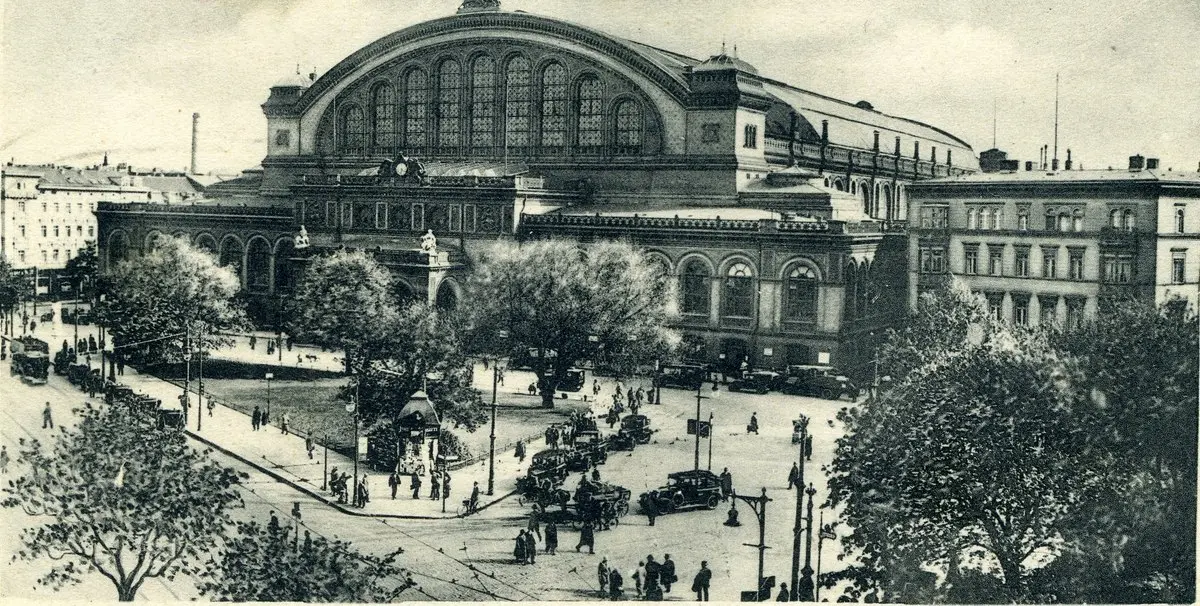 Berlin’deki Anhalter Bahnhof’un büyük kemerli cephesi, önündeki meydanda tramvaylar, otomobiller ve yayalar; 1920’lerden siyah-beyaz kartpostal