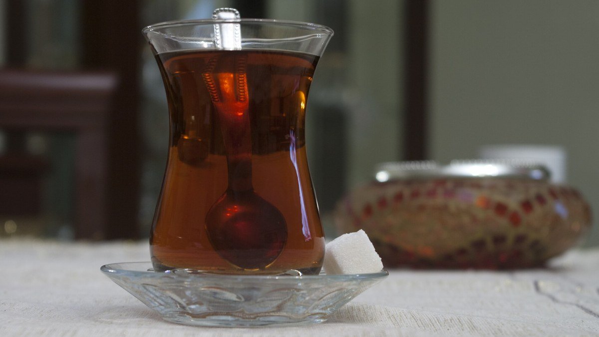 Cam tabağın üzerinde ince belli bardakta demli Türk çayı ve yanında küçük bir şekerlik