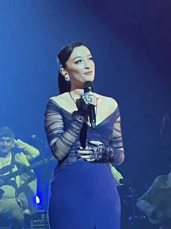 Melike Şahin’in 2022’de Zorlu PSM’deki konserinde siyah tül eldivenleriyle mikrofonu tutarak şarkı söylediği an
