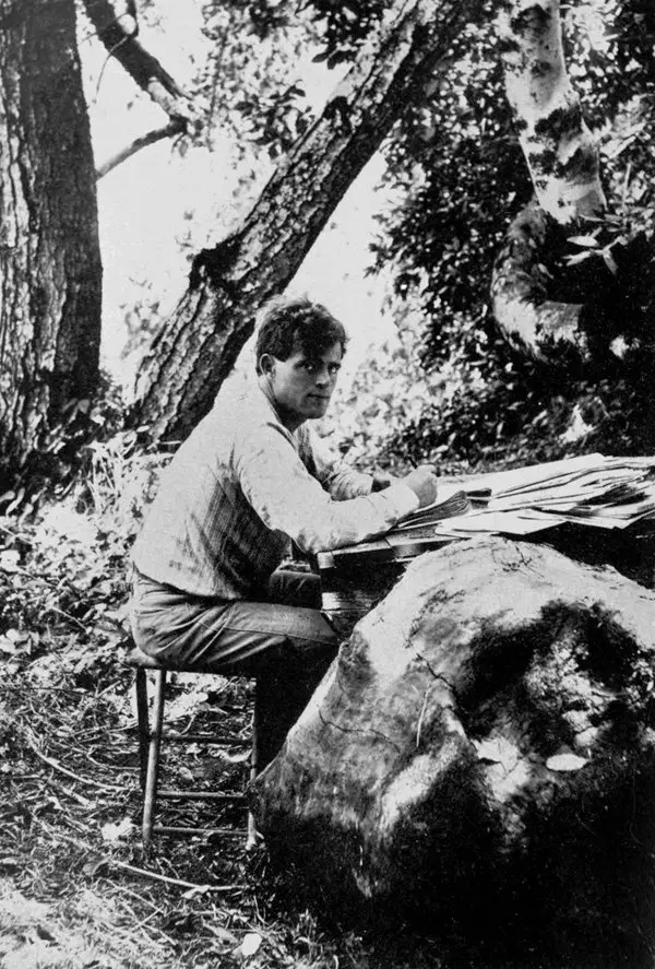 Jack London 1905 yılında açık havada, ağaçların altında bir taşın üzerine koyduğu kâğıtlara yazı yazarken