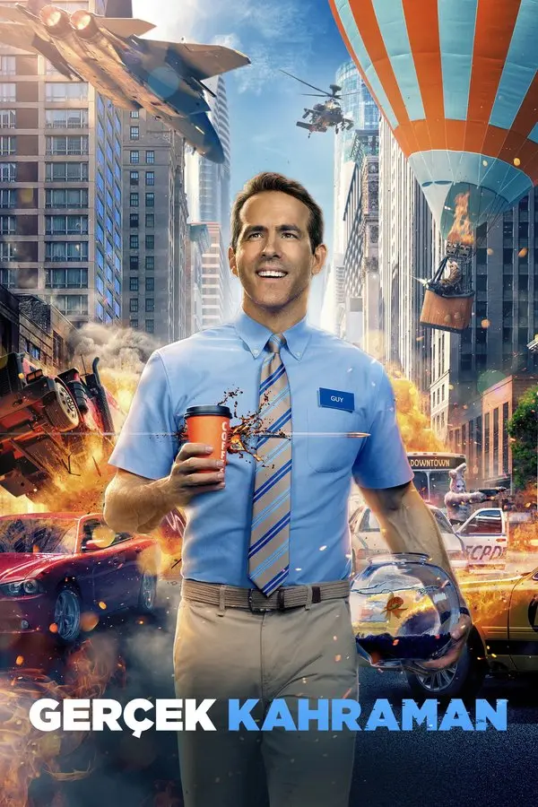 Gerçek Kahraman filminin Türkçe afişi: mavi gömlek ve kravatıyla elinde kahve fincanı tutan gülümseyen Ryan Reynolds, arkasında kaos içindeki bir şehir; altta GERÇEK KAHRAMAN yazısı