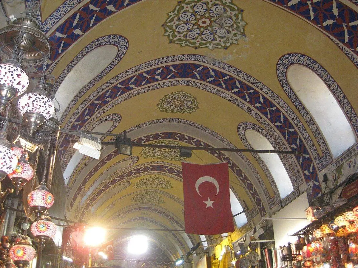 Kapalı Çarşı’nın süslemeli kemerli tavanı, asılı fenerler ve Türk bayrağı