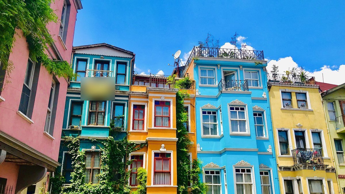 İstanbul Balat'ta yan yana dizilmiş pembe, turkuaz, turuncu, mavi ve sarı boyalı eski apartmanlar
