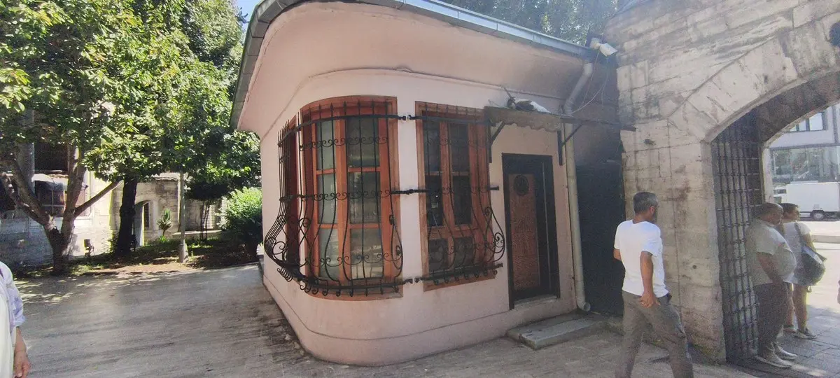 İstanbul Şehzadebaşı’ndaki Şehzade Mehmet Camii avlusunda, kemerli taş kapının yanında, demir parmaklıklı büyük pencereleri olan pembe badanalı küçük muvakkithane yapısı ve önünden geçen ziyaretçiler