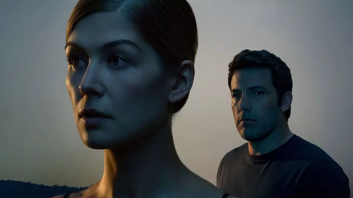 Kayıp Kız (Gone Girl) filminin tanıtım görselinde ön planda Amy Dunne rolündeki Rosamund Pike'ın profili ve arkasında kameraya bakan Nick Dunne rolündeki Ben Affleck