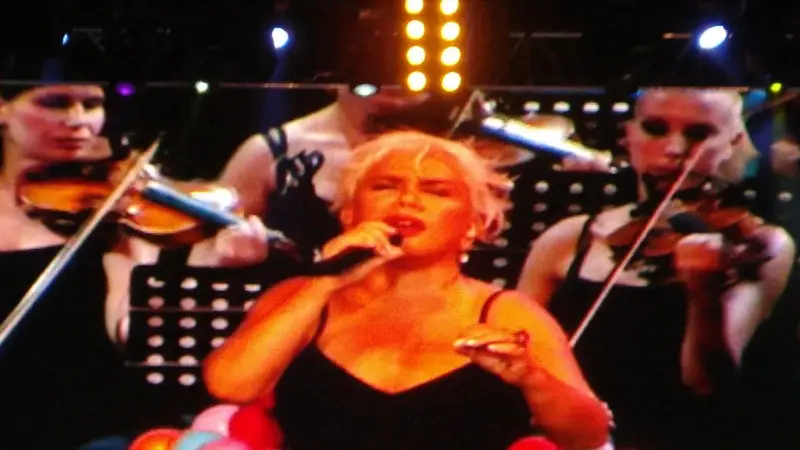 Sezen Aksu’nun 2011’de İstanbul Harbiye Cemil Topuzlu Açıkhava Tiyatrosu’ndaki konserinde, siyah elbisesiyle keman çalan müzisyenlerin önünde mikrofonla şarkı söylerken dev ekrana yansıyan görüntüsü