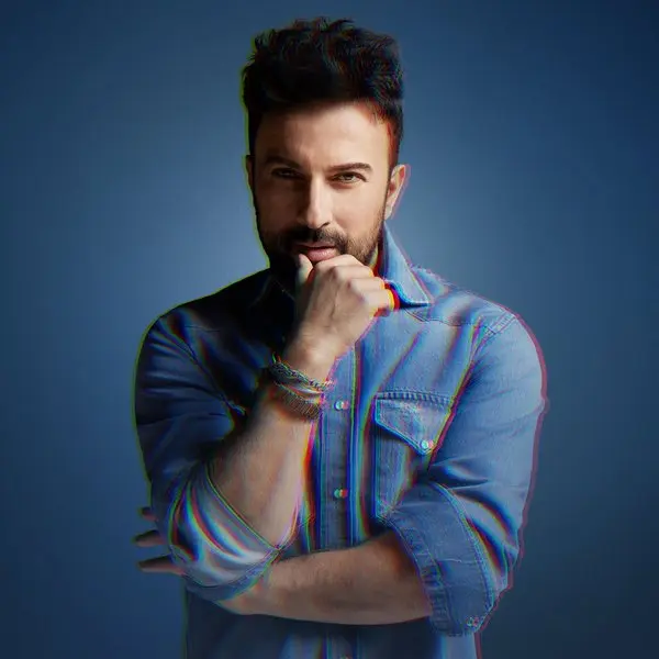 Tarkan’ın Kuantum 51 albüm kapağı; lacivert zemin önünde kot gömlek giymiş, elini çenesine dayamış sakallı Tarkan’ın portresi