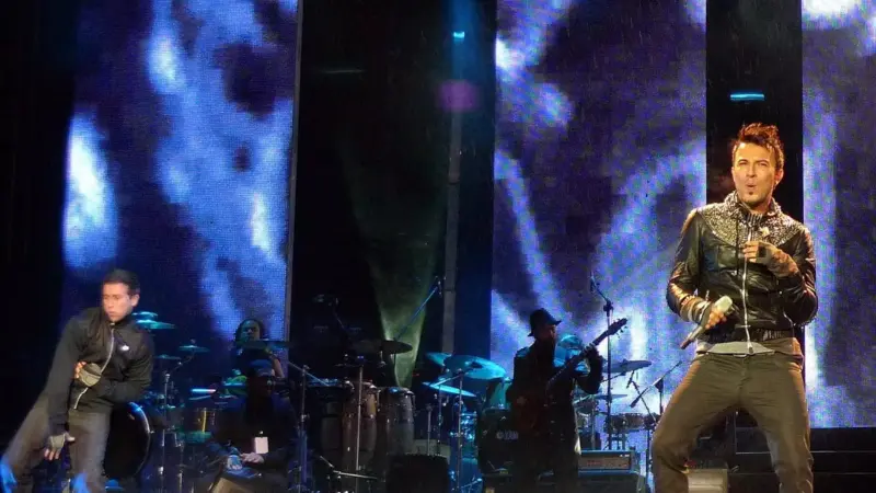 Tarkan’ın 2010’daki İstanbul konserinde sahnede mikrofonla şarkı söylerken çekilmiş fotoğrafı; deri ceketli Tarkan’ın arkasında davul ve gitar çalan müzisyenler ile mavi ışıklı dev ekranlar