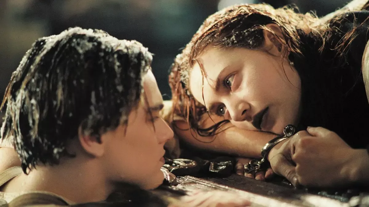 Titanic filminden sahne: buz gibi suda yüzen bir tahta parçasının üzerinde yatan Rose ve suyun içinde onun elini tutan Jack