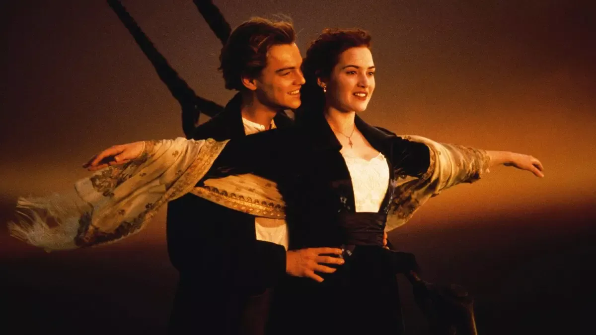Titanic filminden sahne: gün batımında geminin pruvasında kollarını iki yana açmış Rose ve onu belinden tutan Jack