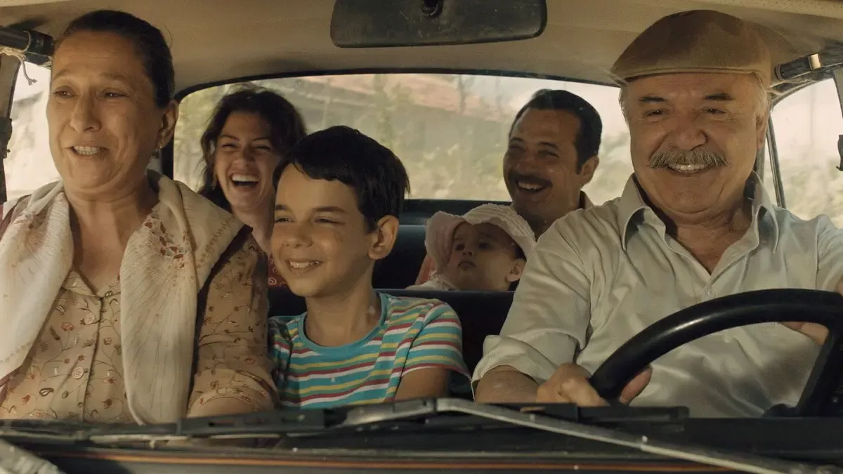 Dedemin İnsanları filminden, eski bir otomobilde yolculuk eden bir aile