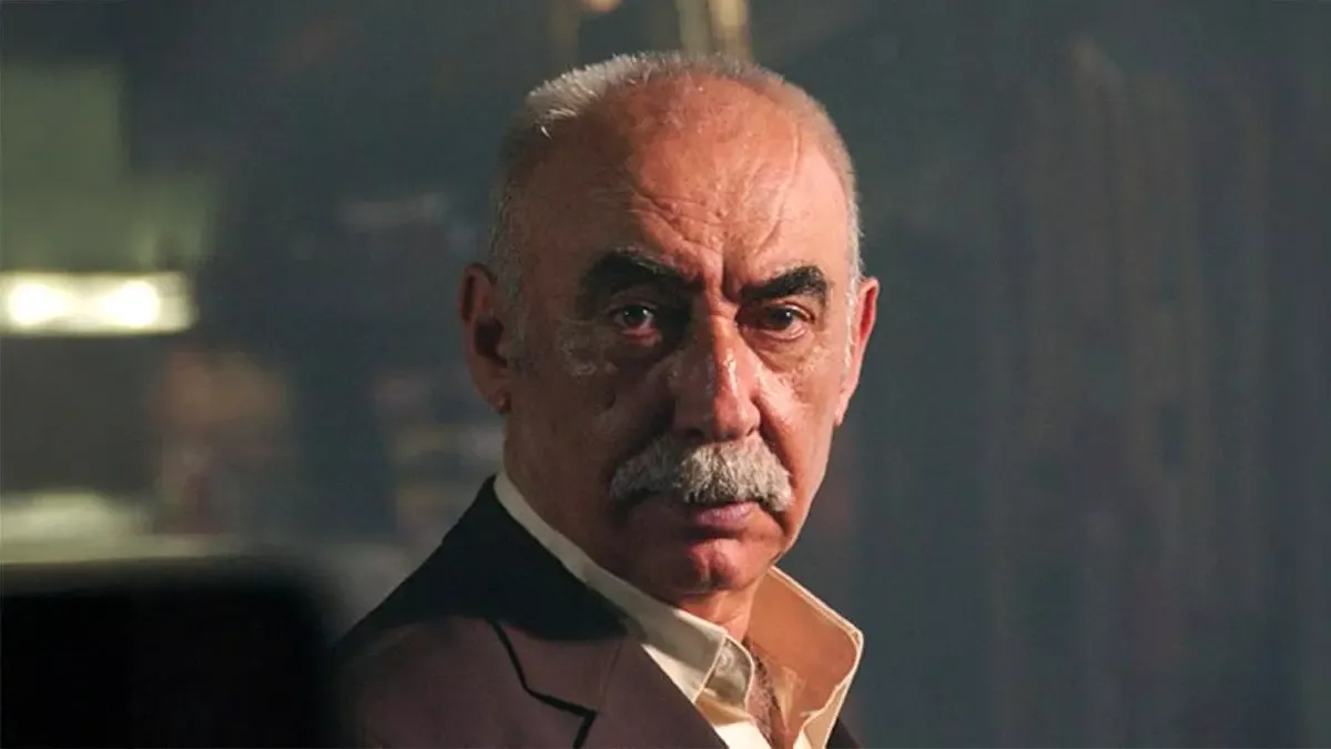 Kabadayı filminden, beyaz bıyıklı, kır saçlı yaşlı bir adamın ciddi bakışlı yakın planı