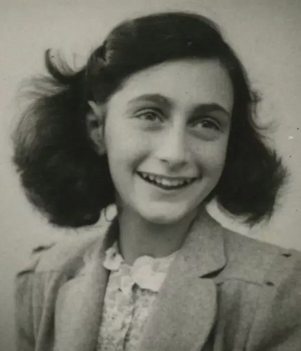 Anne Frank'in koyu saçları omuzlarına dökülmüş hâlde gülümseyerek yana baktığı Mayıs 1942 tarihli siyah-beyaz vesikalık fotoğrafı