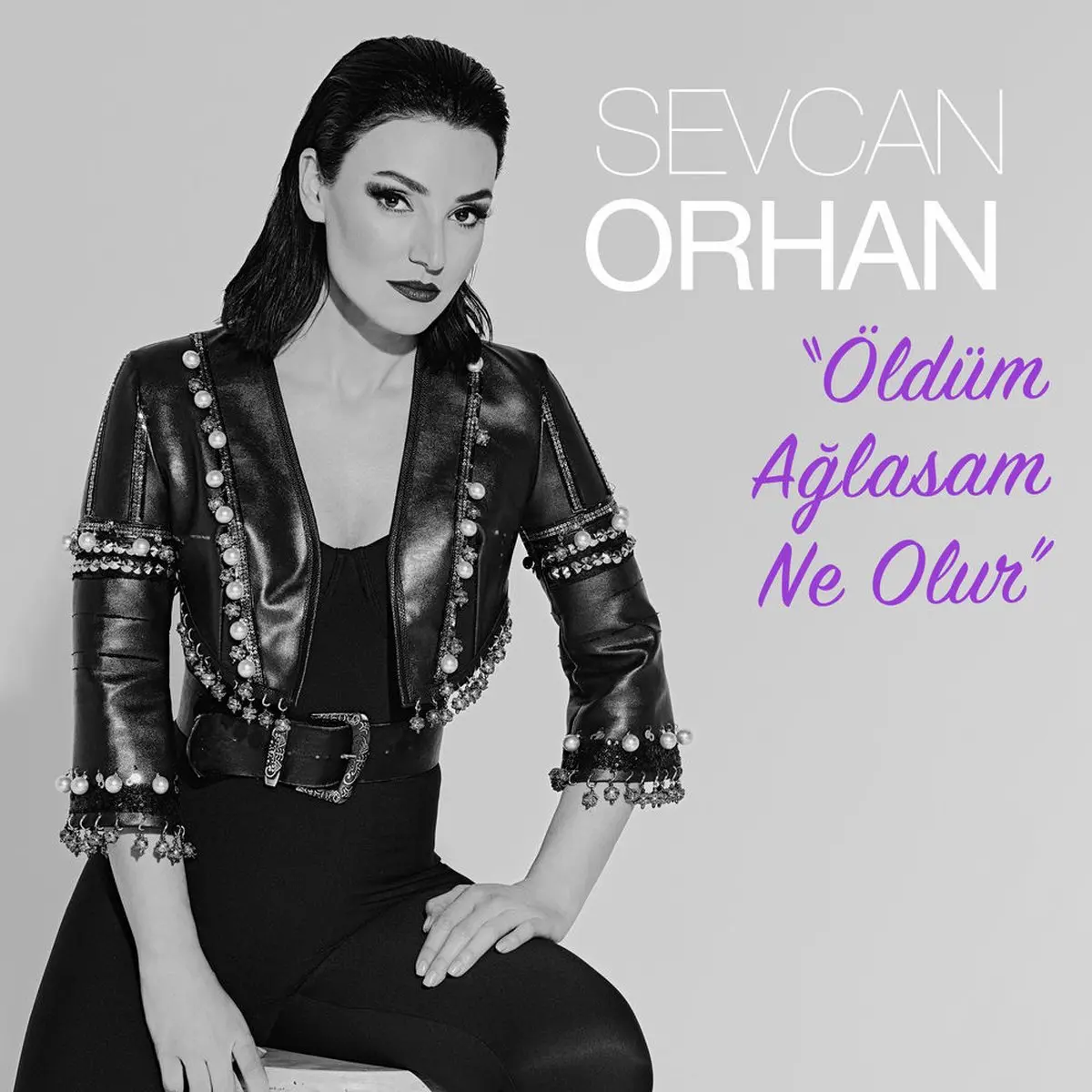 Sevcan Orhan’ın Öldüm Ağlasam Ne Olur single kapağı; siyah beyaz fotoğrafta deri ceketiyle oturan Sevcan Orhan ve yanda mor harflerle şarkı adı