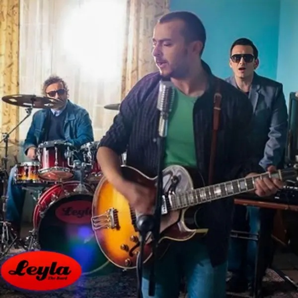 Leyla The Band’in Yokluğunda single kapağı; perdeli bir odada bateri çalan ve elektro gitar tutan grup üyeleri, sol altta kırmızı zemin üzerinde Leyla yazısı