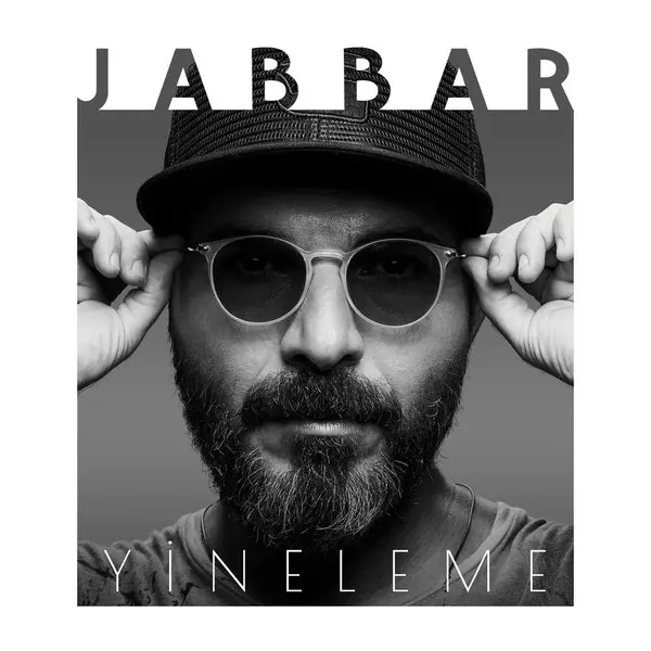 Jabbar’ın Yineleme albüm kapağı; siyah beyaz fotoğrafta şapkalı, sakallı ve yuvarlak güneş gözlüğünü iki eliyle tutan Jabbar, üstte JABBAR altta YİNELEME yazısı