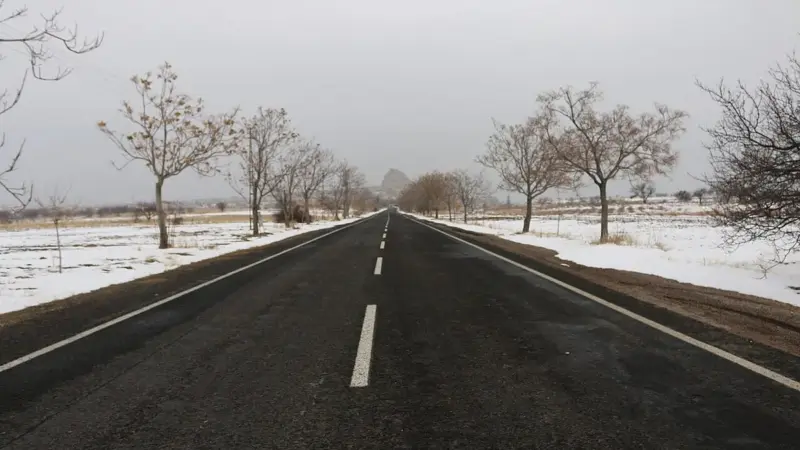 Nevşehir’de Mustafapaşa’ya uzanan, iki yanı karla kaplı ve yapraksız ağaçlarla çevrili, ortası kesik çizgili düz asfalt yol
