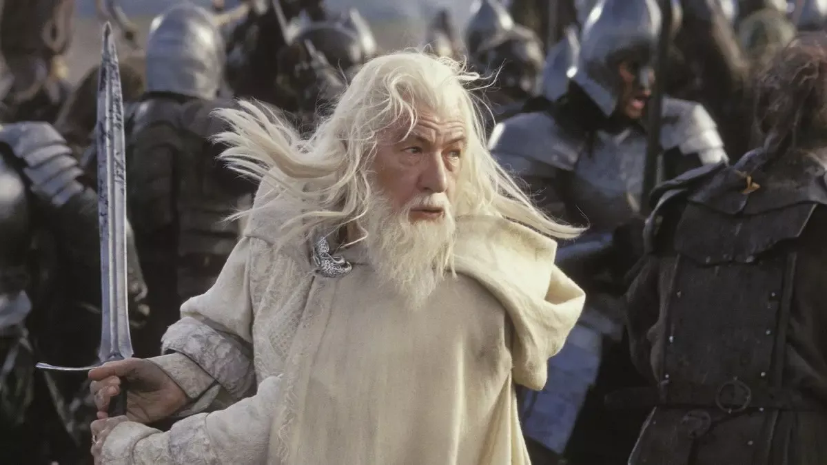 Kralın Dönüşü filminden sahne: Minas Tirith’te miğferli Gondor askerleri arasında kılıcını kavramış, beyaz saçları dalgalanan Ak Gandalf