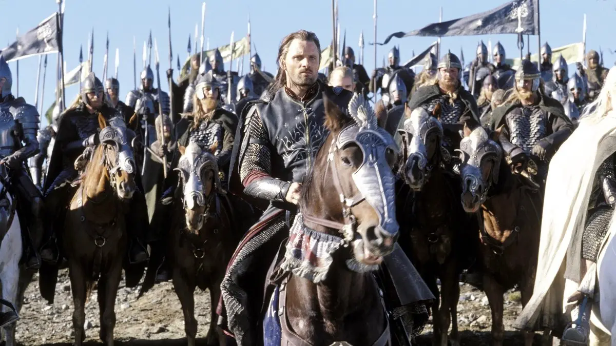 Kralın Dönüşü filminden sahne: mızraklı ve bayraklı süvari ordusunun önünde atıyla ilerleyen zırhlı Aragorn