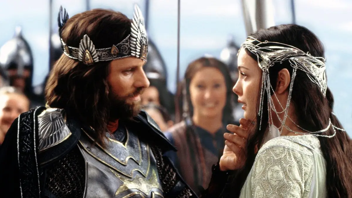 Kralın Dönüşü filminden sahne: başında gümüş taç bulunan Kral Aragorn ve karşısında taçlı Arwen, arkada Minas Tirith halkı