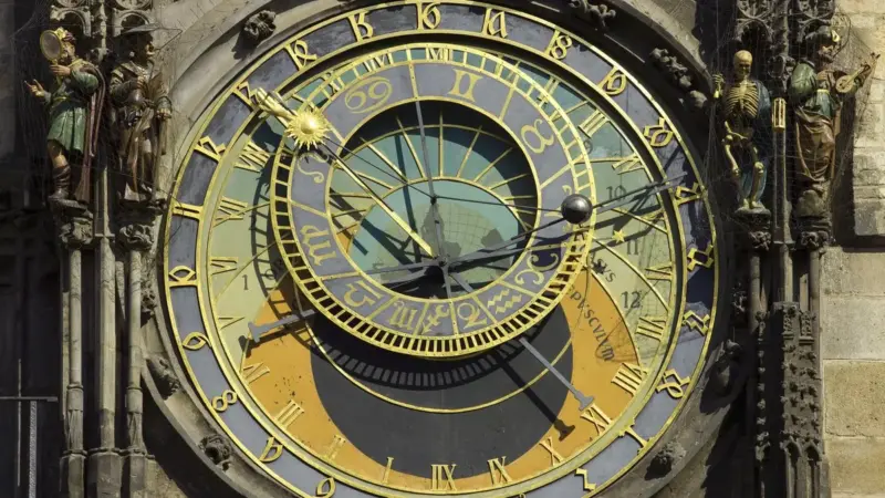 Prag Astronomik Saati’nin kadranı: altın rakamlı astronomik kadran, iki yanında saat başlarında hareket eden heykeller ve elinde kum saati tutan iskelet figürü